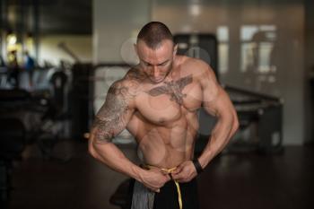 Muscular Shirtless Young Man Measuring Waist With Tape Measure