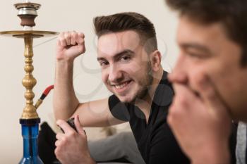 Two Young Brothers Having Happy Time Together Playing Video Games At Home