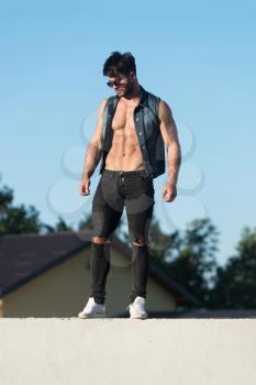 Handsome Man Standing Strong and Posing at Outdoors Wearing Black Jeans - Background of Sky