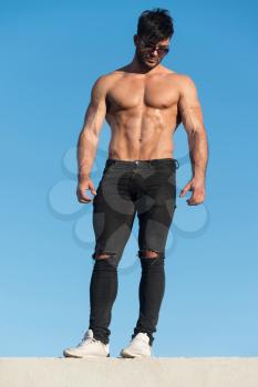 Handsome Man Standing Strong and Posing at Outdoors Wearing Black Jeans - Background of Sky