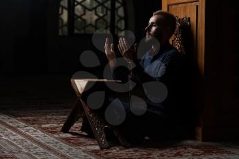 Adult Muslim Man Is Reading The Koran In The Mosque