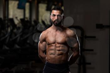 Healthy Young Tattoo Man Standing Strong In The Gym And Flexing Muscles - Muscular Athletic Bodybuilder Fitness Model Posing After Exercises