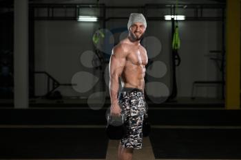 Young Man Exercising With Kettle Bell And Flexing Muscles - Muscular Athletic Bodybuilder Fitness Model Exercises