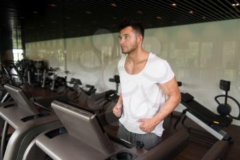 Healthy Man Running On Treadmill In A Modern Fitness Center