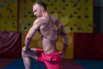 Handsome Young Man Standing Strong In The Gym And Flexing Muscles - Muscular Athletic Bodybuilder Fitness Model Posing After Exercises