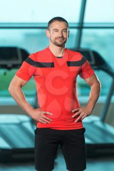 Portrait Of Personal Trainer In Sports Outfit In Fitness Center Gym Standing Strong