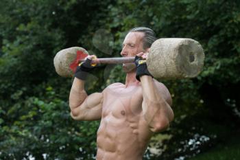 Muscular Adult Man Doing A Exercise For Shoulders With Made Hand Barbell Outdoors Workout