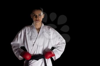 Young Muslim Woman In Traditional Kimono Practicing Her Karate Moves - Isolated On Black Background