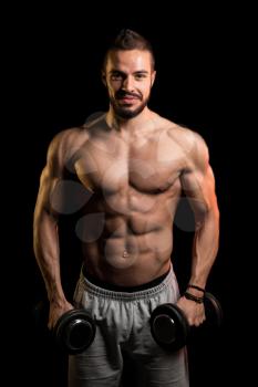Muscular Model Doing Heavy Weight Exercise For Biceps With Dumbbells On Black Background