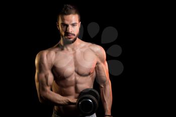 Young Man Working Out Biceps With Dumbbells On Black Background - Dumbbell Concentration Curls
