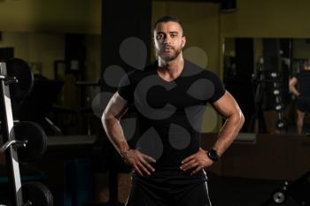 Handsome Young Man Standing Strong In Black T-Shirt And Flexing Muscles - Muscular Athletic Bodybuilder Fitness Model Posing After Exercises