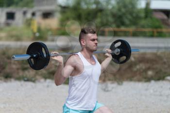 Man Working Out Legs In Outdoors With Barbell