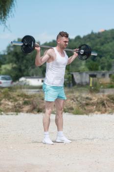 Man Working Out Legs In Outdoors With Barbell