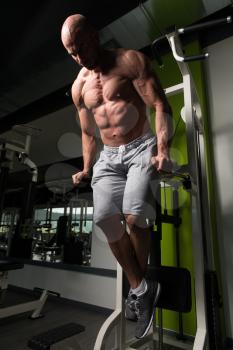 Muscular Fitness Bodybuilder Doing Heavy Weight Exercise For Triceps And Chest on Parallel Bars In The Gym