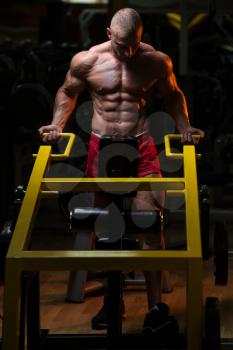 Bodybuilder Doing Heavy Weight Exercise For Trapezius On Machine