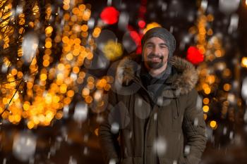 Having Fun at a Christmas Fairy - Young Cheerful Man Dressed Warm Is Standing In Holiday Market