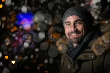 Having Fun at a Christmas Fairy - Young Cheerful Man Dressed Warm Is Standing In Holiday Market