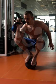 Athlete Doing Kettle Bell Exercise On Medicine Ball As Part Of Bodybuilding Training In Gym