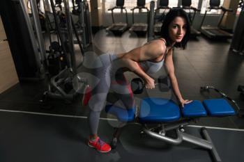Muscular Fitness Woman Athlete Doing Heavy Weight Exercise For Back With Dumbbells In The Gym