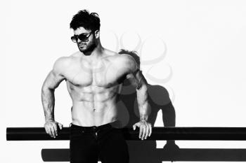 Handsome Young Model Standing Strong Outdoors and Flexing Muscles - Muscular Athletic Bodybuilder Man Posing After Exercises - a Place for Your Text