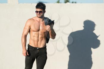 Handsome Young Model Standing Strong Outdoors and Flexing Muscles - Muscular Athletic Bodybuilder Man Posing After Exercises - a Place for Your Text