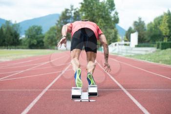 Fit and Confident Man in Starting Position Ready for Running