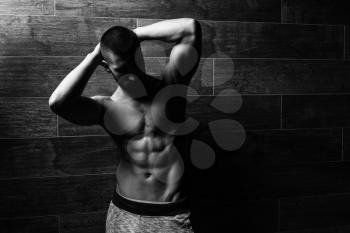 Portrait of a Young Physically Fit Man Showing His Well Trained Body - Muscular Athletic Bodybuilder Fitness Model Posing After Exercises on Wall Near the Wall - a Place for Your Text