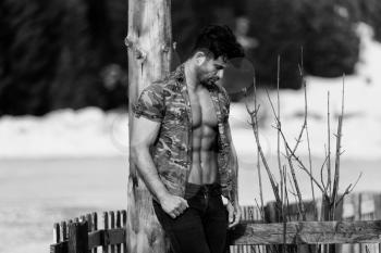 Healthy Young Man Standing Strong Flexing Muscles While Wearing Black Jeans - Muscular Athletic Bodybuilder Fitness Model Posing Outdoors - a Place for Your Text