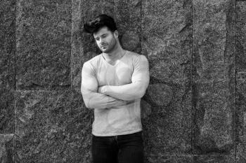 Cool Fashion Man in Blue Jeans Standing and Looking Away - Against Brick Wall on Copy Space