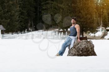 Healthy Young Man Standing Strong Flexing Muscles While Wearing Blue Jeans - Muscular Athletic Bodybuilder Fitness Model Posing Outdoors - a Place for Your Text