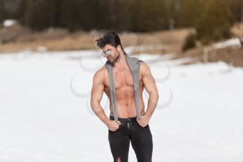 Handsome Young Model Standing Strong Outdoors and Flexing Muscles - Muscular Athletic Bodybuilder Man Posing - a Place for Your Text