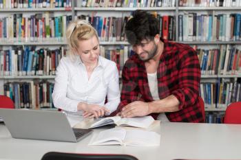 In The Library Handsome Two College Students With Laptop And Books Working In A High School University Library