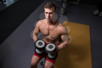 Strong Man In The Gym And Exercising Chest With Dumbbells - Muscular Athletic Bodybuilder Fitness Model Exercise