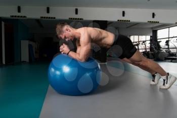 Young Man Athlete Doing Abs Exercise On Ball As Part Of Bodybuilding Training