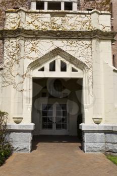 Large door way into building with vines covering the stone