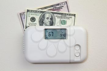 In door heating thermostat set at a room temperature and money