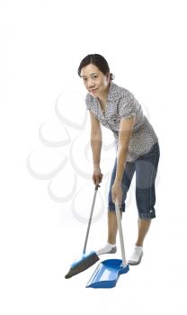 Asian lady  with broom and dust pan while wearing causal clothing on white background