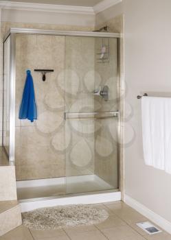 Clean master bathroom shower with scrub rag, squeegee and soap in dish