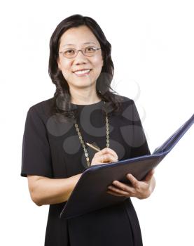 A portrait Vertical photo of a mature Asian woman wearing a dark dress while holding a folder and pen on a white background