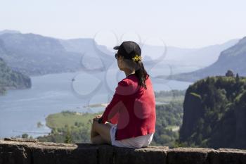 Horizontal photo of mature woman looking at Columbia River Gorge located in the Northwest section of the United States