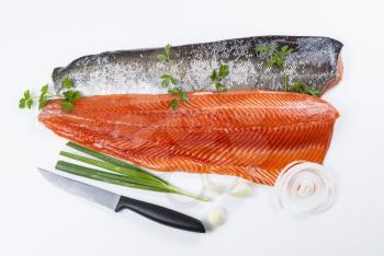Wild Salmon Fillets with parsley, onion, garlic and knife on white background