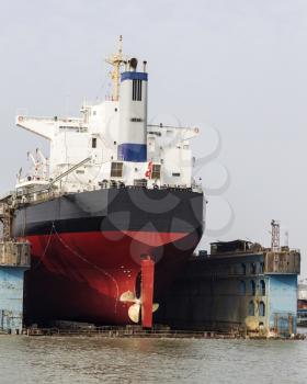 Black and red cargo ship dock for repairs in Huangpu River China
