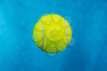 close up shot of new tennis ball with sky blue background