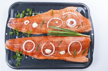 Wild Salmon Fillets in baking pan with herbs and spices on white background