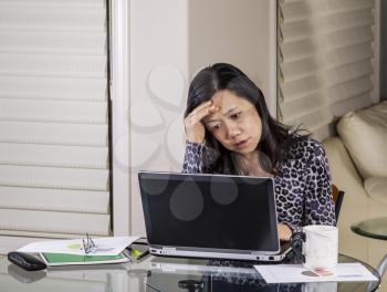 Mature women looking worried while working in home office