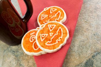 Horizontal photo of three seasonal sugar cookies, on cloth napkin, next to ceramic mug on natural stone counter top 