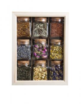Vertical photo of dried flowers and plants inside wooden box with individual glass jars isolated on white 