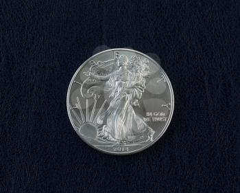 Closeup photo of an uncirculated American Silver Eagle Coin Dollar on dark blue vinyl holder
