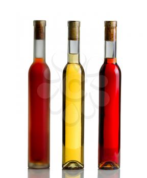 Vertical image of three unopened wine bottles on white with reflection

