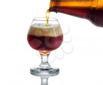 Pouring dark beer into glass goblet on white with reflection